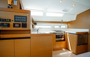 Uma cozinha compacta com armários de madeira, forno embutido e micro-ondas.