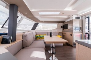 Un interior moderno con un sofá, una mesa, un televisor y una zona de cocina.