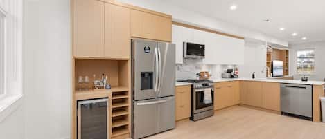 Una cocina moderna con electrodomésticos de acero inoxidable, gabinetes de madera y un horno empotrado.