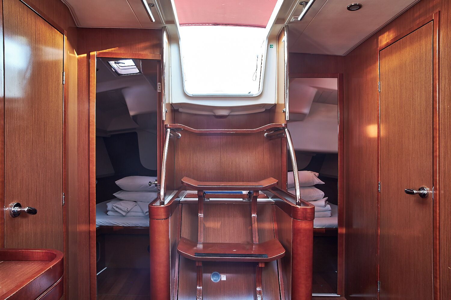 A compact, well-lit interior with a bed, a small table, and a built-in shelf.