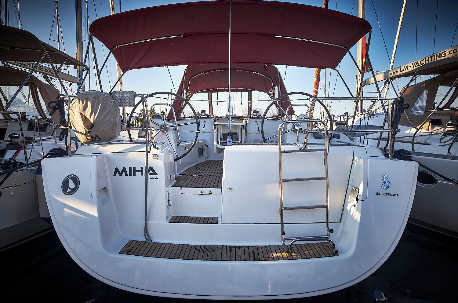 A boat with a white hull, a red canopy, and the name 'MIHA' on the side.