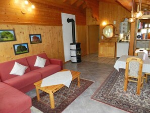 A cozy living room with a red sofa, a wooden coffee table, and a patterned rug.