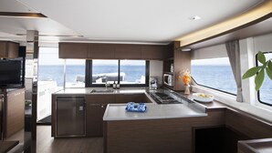 Una cucina moderna con un'ampia finestra, un piano cottura integrato e un piccolo frigorifero.