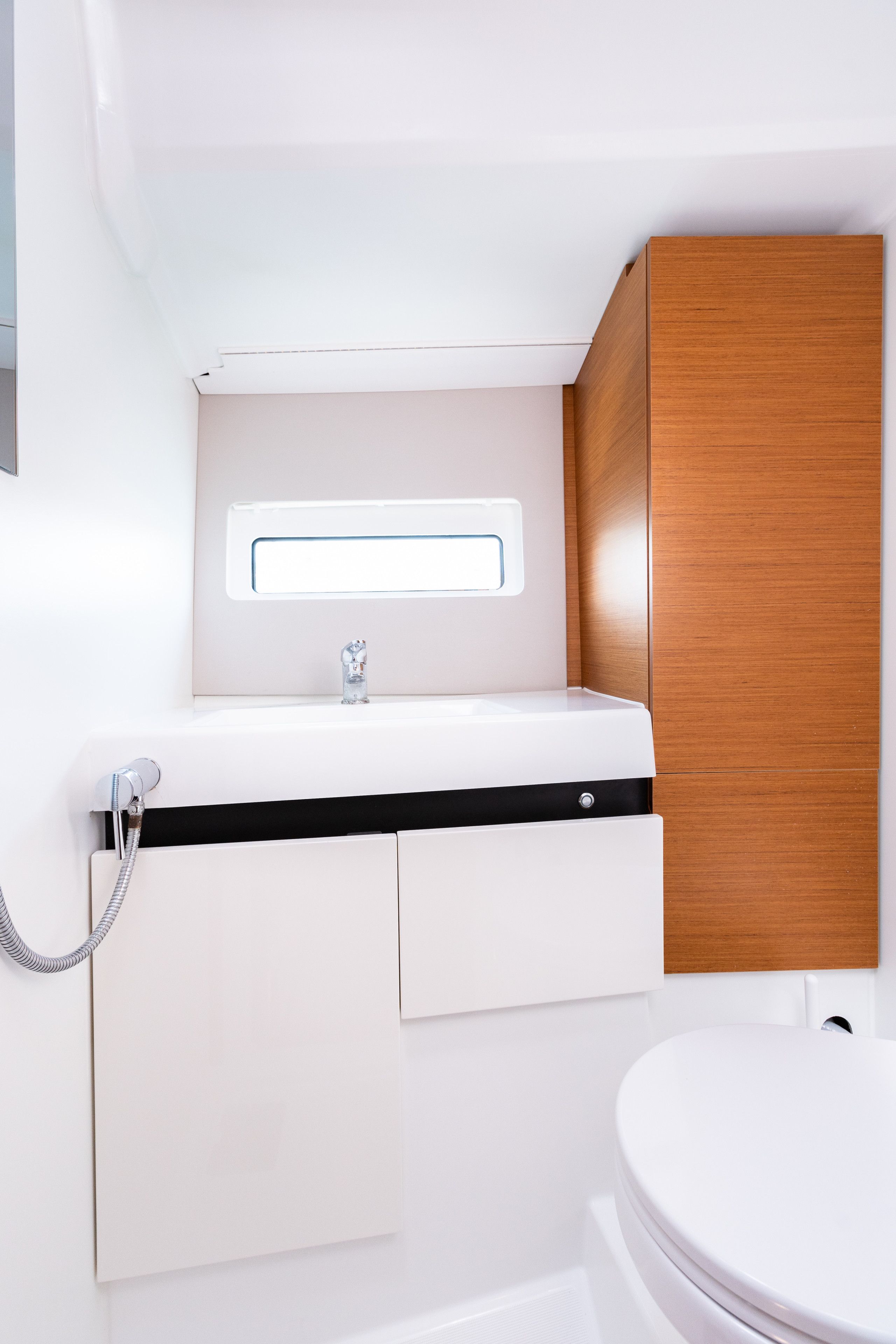 A bathroom with a white sink, a mirror, and a wooden cabinet.