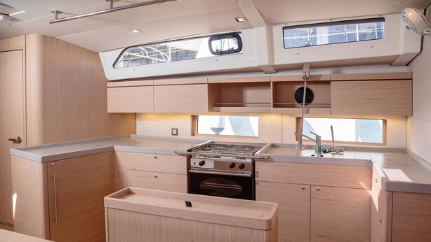 A compact kitchen with a stove, sink, and upper storage cabinets. - Sun-Kissed Sailing Adventure in the Sporades Islands from Volos, Thessaly (Volos)