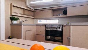 Eine kompakte Küche mit Backofen, Spüle und einem Fenster über der Arbeitsfläche.
