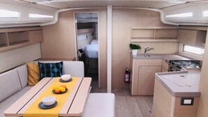 Ein kompaktes Wohnmobil-Interieur mit Essbereich, Küchenzeile und Schlafkoje.