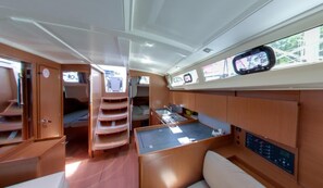 A compact, well-lit interior with a kitchenette, seating area, and a small table. - Dubrovnik Delight: A Sun-Kissed Sailing Experience (Komolac)