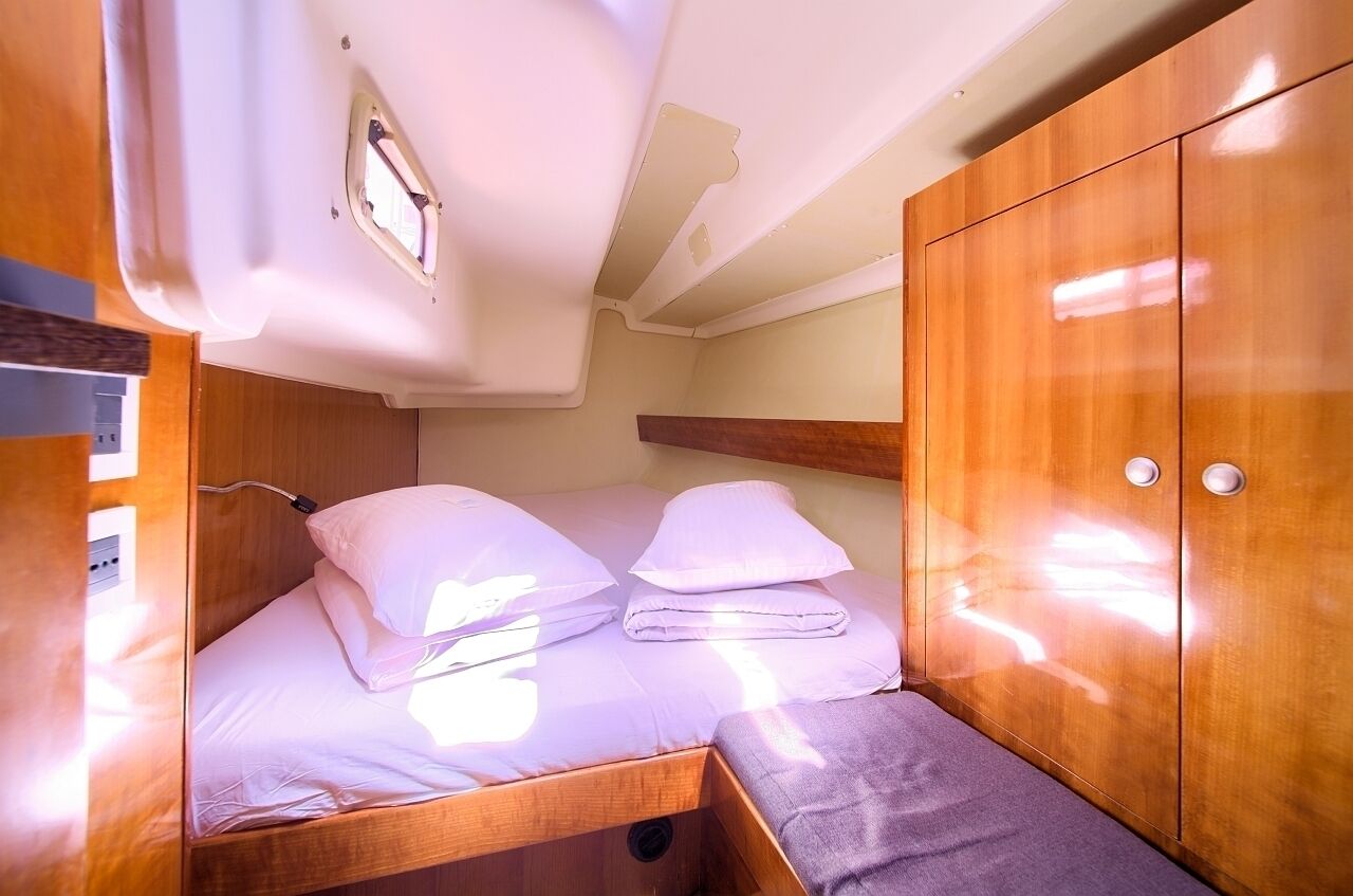 Una cabaña compacta con literas, muebles de madera y un ventanal pequeño.