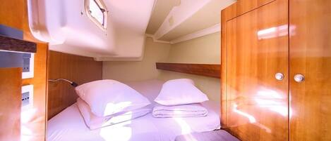 A compact cabin with a bunk bed, wooden cabinetry, and a small window.