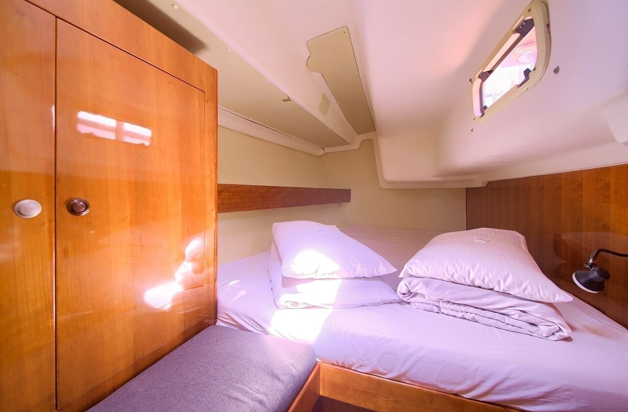 Una cabaña pequeña con cama, armario y ventana.
