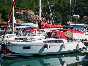 A marina with multiple sailboats docked, featuring a calm water surface and a backdrop of buildings and greenery. - Dubrovnik Delight: A Sun-Kissed Sailing Experience (Komolac)
