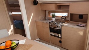Une petite cuisine équipée d’une cuisinière, d’un évier et d’une petite fenêtre.