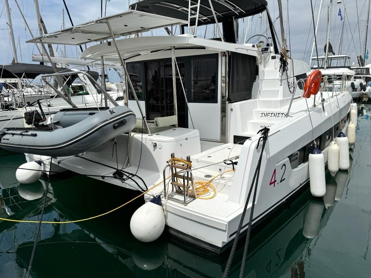 A white boat with the number 42 docked at a marina.