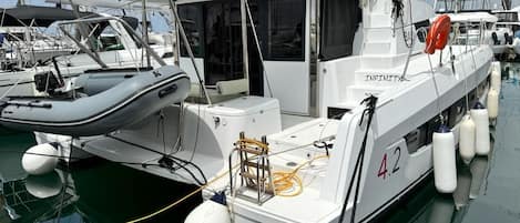 A white boat with the number 42 docked at a marina.