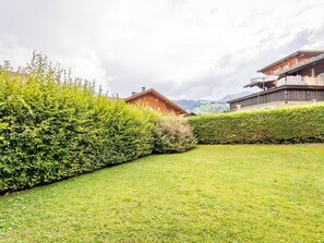 A well-maintained garden with a wooden building, a hedge, and a clear sky. - Résidence Sonnegg (Puric) Appartement/Fewo, Dusche oder Bad, WC, 1 Schlafraum by Interhome (Zweisimmen)