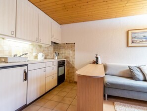 A compact kitchen with white cabinets, a built-in oven, and a sink. - Résidence Sonnegg (Puric) Appartement/Fewo, Dusche oder Bad, WC, 1 Schlafraum by Interhome (Zweisimmen)