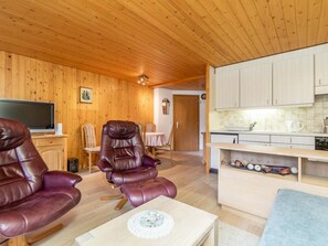 A cozy living room with leather chairs, a television, and a small table with a decorative item. - Résidence Sonnegg (Puric) Appartement/Fewo, Dusche oder Bad, WC, 1 Schlafraum by Interhome (Zweisimmen)