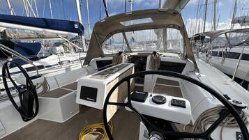 L'intérieur d'un bateau, avec un volant, un panneau de commande et des cordes enroulées.