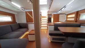 Een compacte ruimte met een bank, een eettafel en een kitchenette.