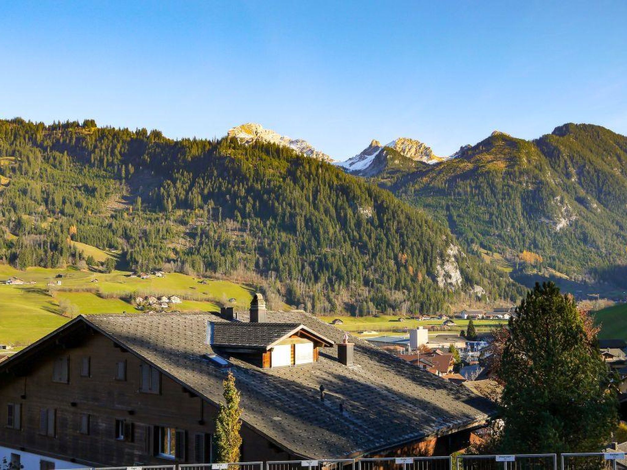 Paisagem montanhosa com uma casa de telhado inclinado e chaminé.