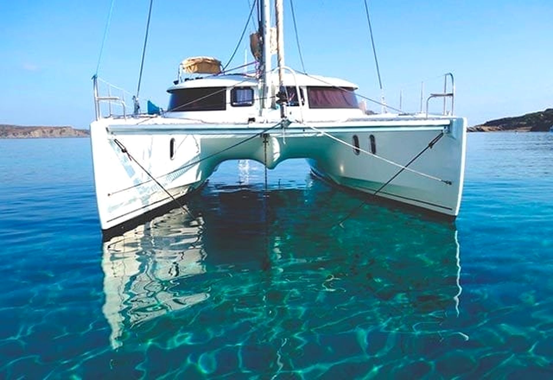Un trimarán blanco con camarote y proa.