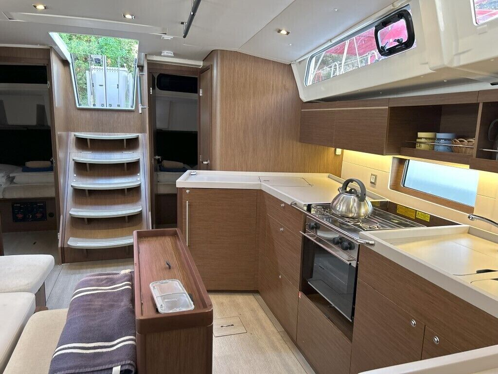 A compact kitchen with a stove, oven, and a window above the sink.