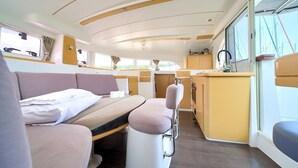 A compact interior with a bed, seating area, and a small kitchenette. - Sun-Kissed Sailing Adventure in Northern Croatia (Punat)
