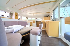 A compact interior with a bed, seating area, and a small kitchenette. - Sun-Kissed Sailing Adventure in Northern Croatia (Punat)