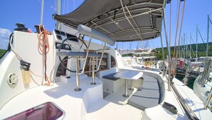 A boat deck with a table, chairs, and a canopy. - Sun-Kissed Sailing Adventure in Northern Croatia (Punat)