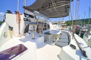 A boat deck with a table, chairs, and a canopy. - Sun-Kissed Sailing Adventure in Northern Croatia (Punat)