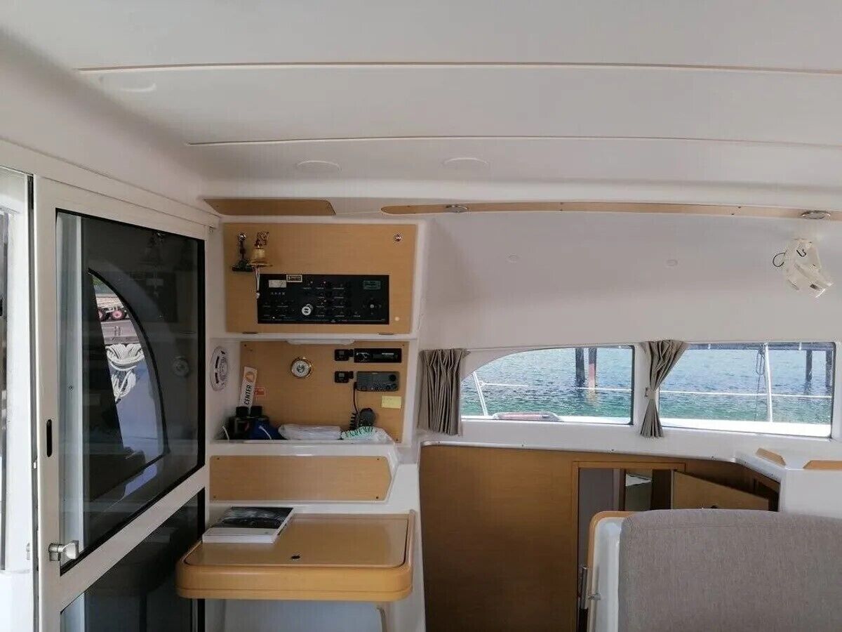 Un interno compatto con un pannello di controllo, un tavolino e una finestra con vista sull'acqua.