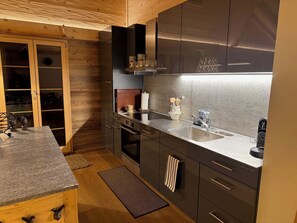 A modern kitchen with a built-in oven, a stainless steel sink, and wooden cabinetry. - Heimersberg Appartement/Fewo, Bad, WC 3-Bettwohnung by Interhome (Zweisimmen)