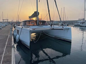 Un puerto deportivo con un velero blanco amarrado al muelle.