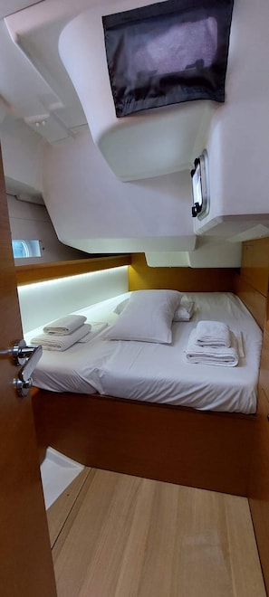 Ein Hotelzimmer mit einem Bett, einem an der Wand befestigten Fernseher und Holzboden.