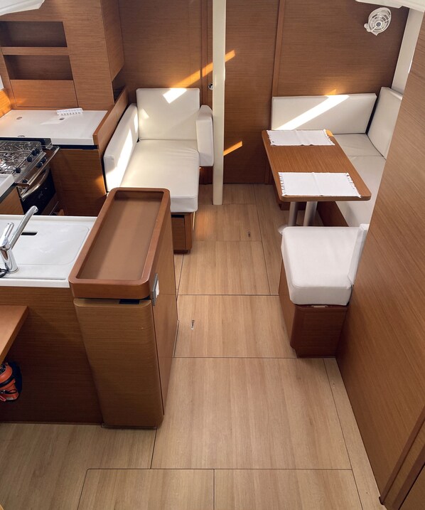A compact kitchenette with a stove, sink, and storage.