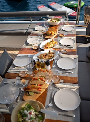A dining table set for a meal with various dishes, glasses, and cutlery.