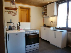 A compact kitchen with a stove, oven, and white cabinets. - Beatrice Appartement/Fewo, Dusche oder Bad, WC 3-Bettwohnung by Interhome (Zweisimmen)
