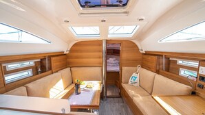 A compact, well-lit interior with a dining area, seating, and a small kitchenette. - Sun-Kissed Sailing Adventure in Split, Croatia (Kaštel Gomilica)