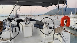 A sailboat with a covered deck, a steering wheel, and a lifebuoy. - Sun-Kissed Sailing Adventure in the Ionian Islands, Lefkada (Lefkada)