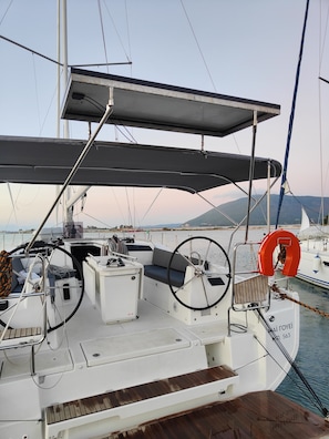 Eine Segelyacht mit abgedecktems Deck, Steuer und Rettungsring.