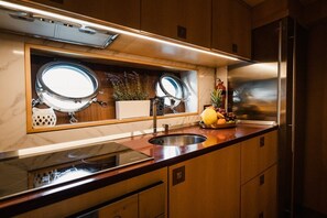 Una cocina moderna con un refrigerador de acero inoxidable, un lavamanos doble y un horno empotrado.