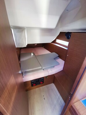 Ein gemütlicher Innenraum mit einem Bett, einer Bedienkonsole und einem kleinen Fenster.