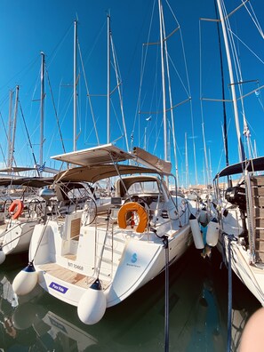 Ein Yachthafen mit mehreren Segelbooten, die vertäut sind, mit Masten, Tauvorlagen und Rettungsringen.
