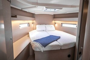 A compact, well-lit bedroom with a bed, bedside tables, and a skylight. - Sun-kissed Sailing Adventure in Istria, Croatia (Pomer)