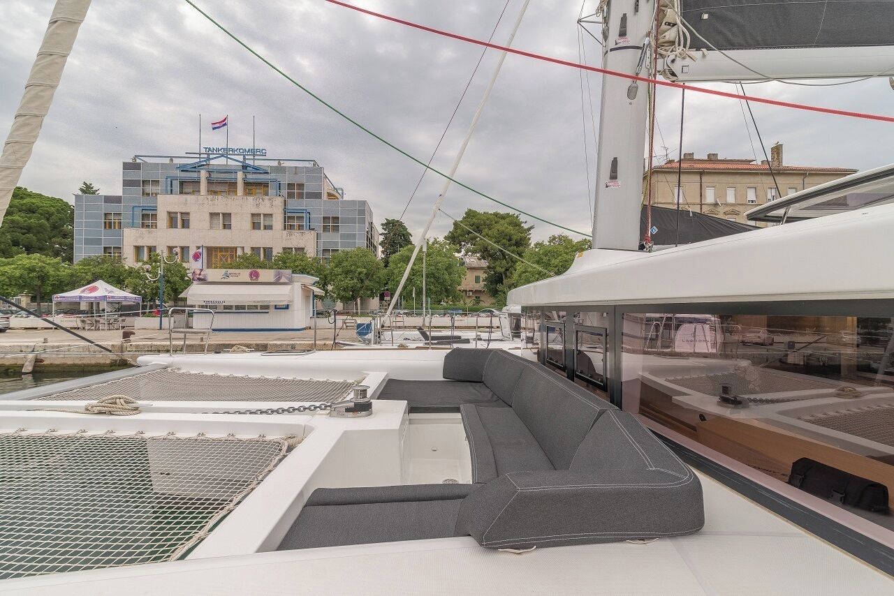 En lyxyacht med modern design, utrustad med en stor sittgrupp och ett täckt däck.