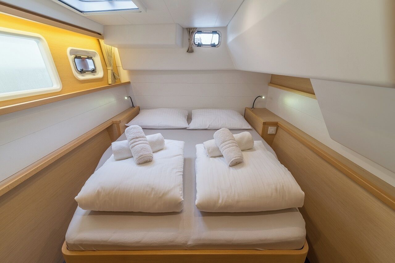 A compact cabin with two beds, a small window, and a skylight.