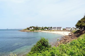 A coastal hotel with a beach view, a rocky shoreline, and lush greenery. - Sun-Kissed Sailing Adventure in Golfo de Morbihan, Brittany (Arzon)