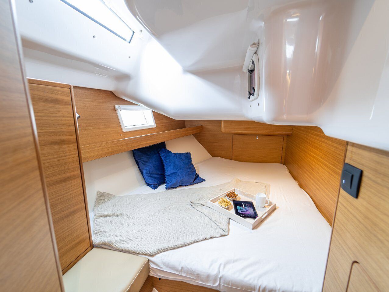 Une petite cabine équipée d’un lit superposé, d’une petite table et d’une fenêtre.