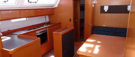 A compact kitchen with a sink, stove, and storage cabinets.